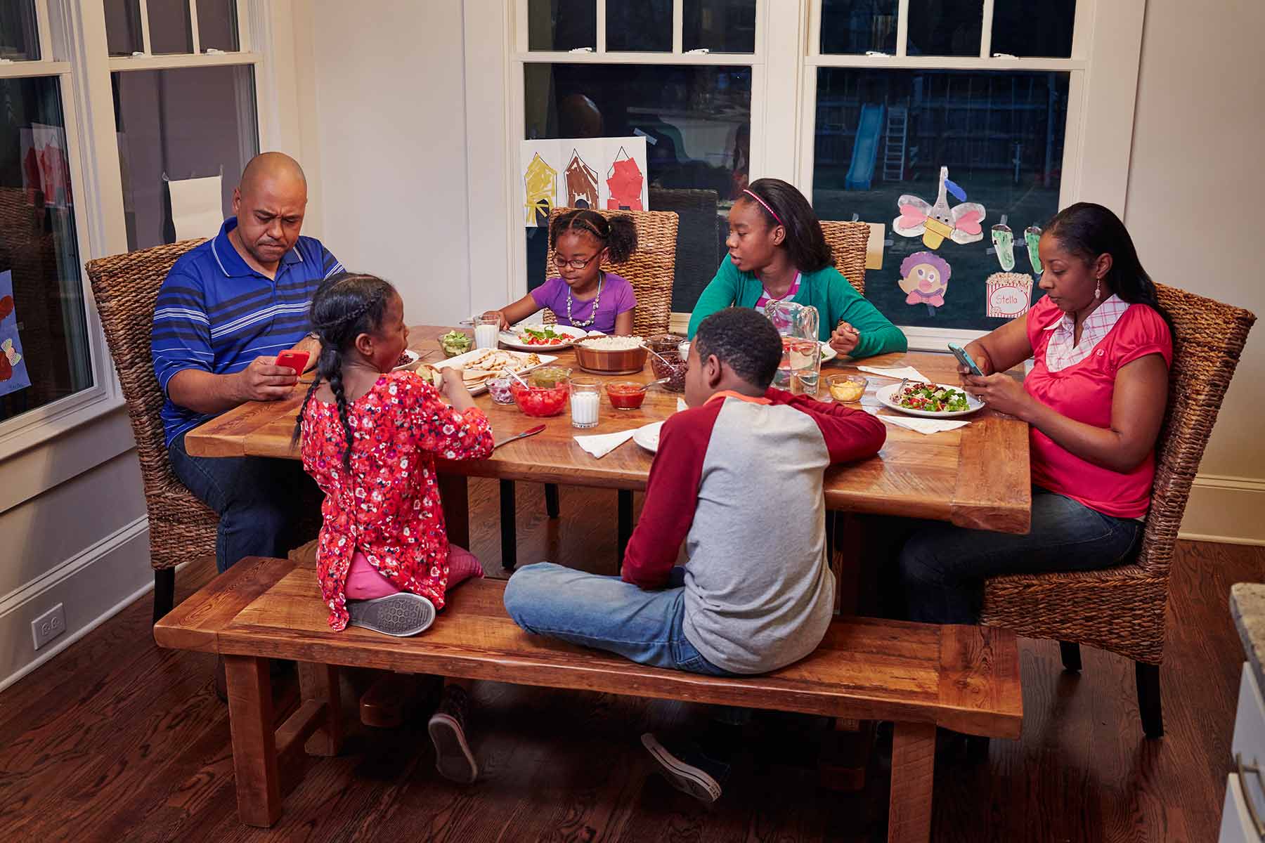 Family eating dinner and using phones